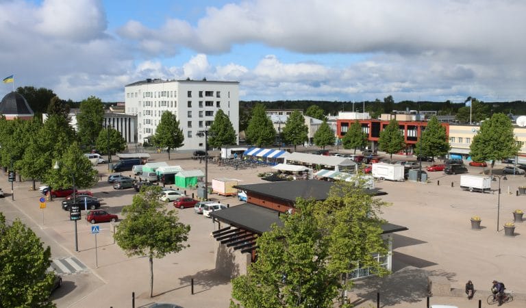 Torialue myyntikojuineen. Etualalla torirakennus ja torin sivuilla pysäköintialueet. Vasempaan laitaan jää lipputorni, jonka tangossa Ukrainan lippu.