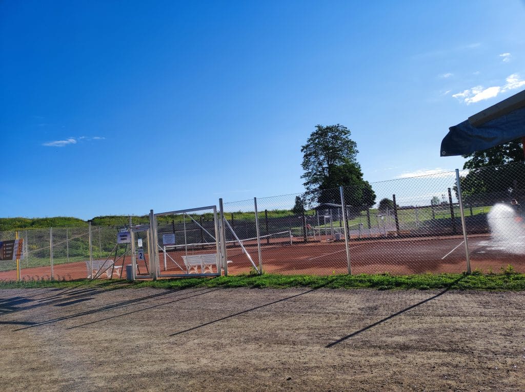 Aidattu tenniskenttä vallin laidalla.