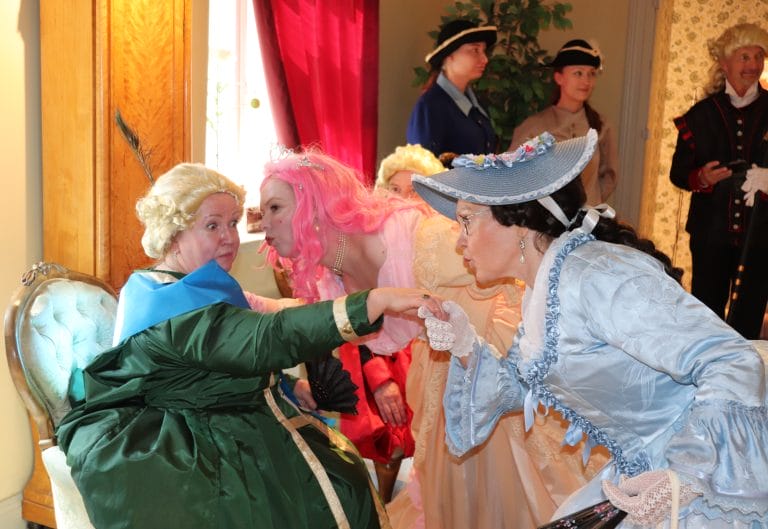 Kuva porvarisvaimoiksi pukeutuneista esiintyjistä.