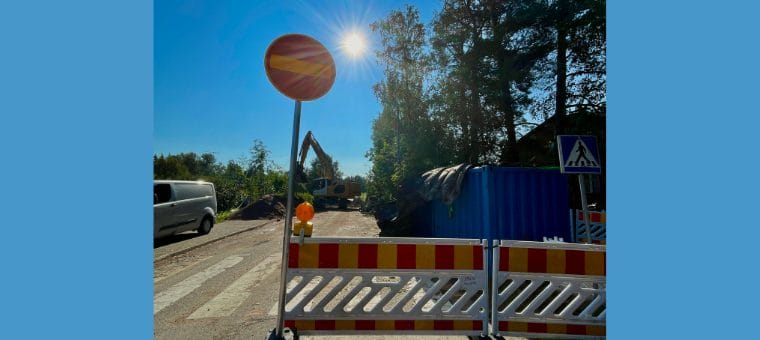 Kielletty ajosuunta ja liikenneopasteet sekä kaivuri tiellä.