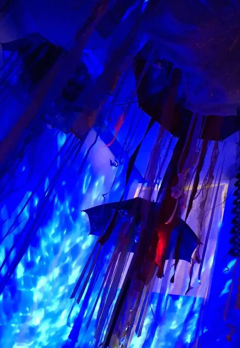 Taidetta sinisessä tunnelmavalaituksessa.