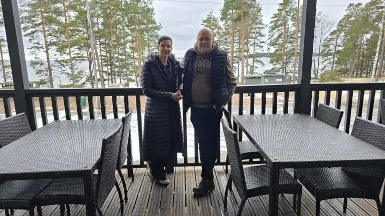 Uudet yrittäjät ravintolarakennuksen terassilla.