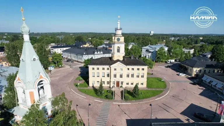 Raatihuoneen ilmakuva ja maailmanluokan pikkukaupunki Hamina-logo.