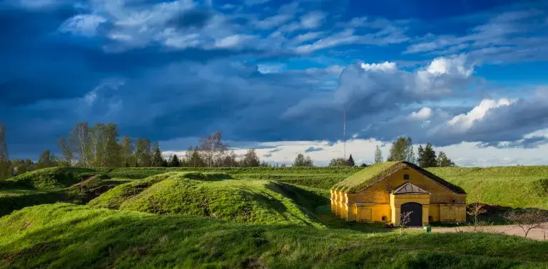 Keltainen rakennus vallien edessä.