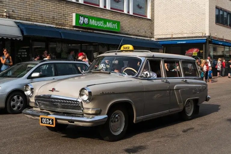 Elomarkkinakulkueessa autoja.