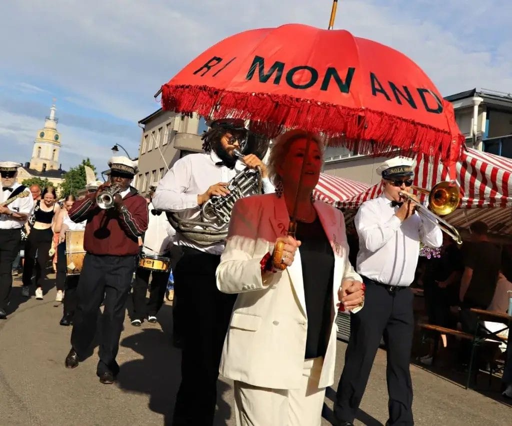 Kulkue, jossa soittajia ja ihmisiä kävelemässä.