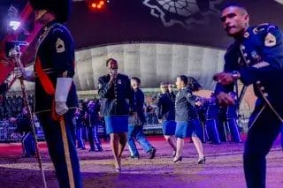 Esiintyjiä Hamina Bastionin hiekkakentällä valaistuksessa.