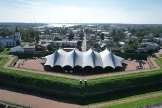 Linnoitusvallien takana oleva valkoinene telttakatos, takana kaupunkinäkymää.