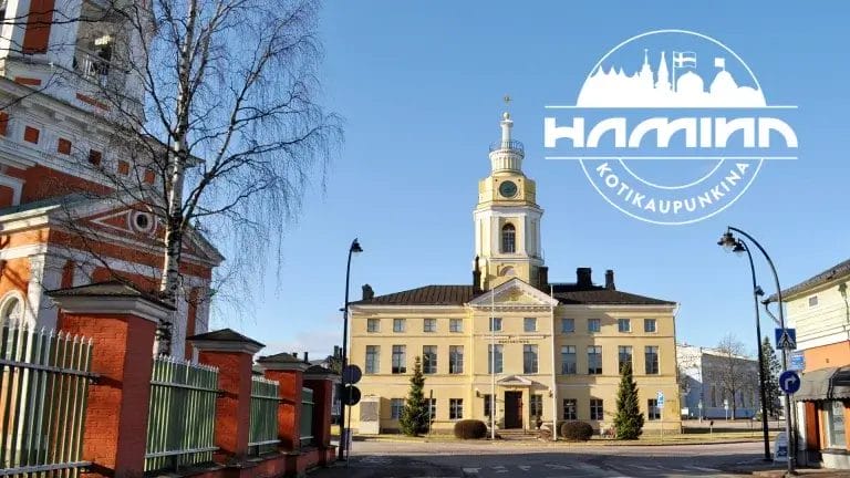 Raatihuoneen kuva Kadettikoulunkadun suunnasta ja kotikaupunkina Hamina-logo.
