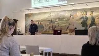 Mies puhumassa yleisölle Raatihuoneella.