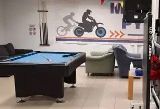 Tila, jossa bilgardipöytä ja seinamaalauksia.