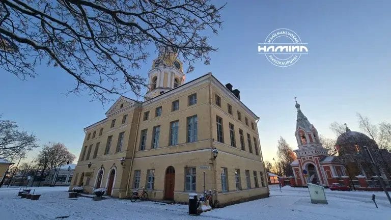 Raatihuone talvella ja Haminan logo.