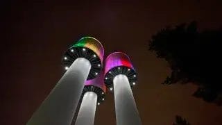 Taskalinmäen kolme vesitornia sateenkaaren värein valaistuna.