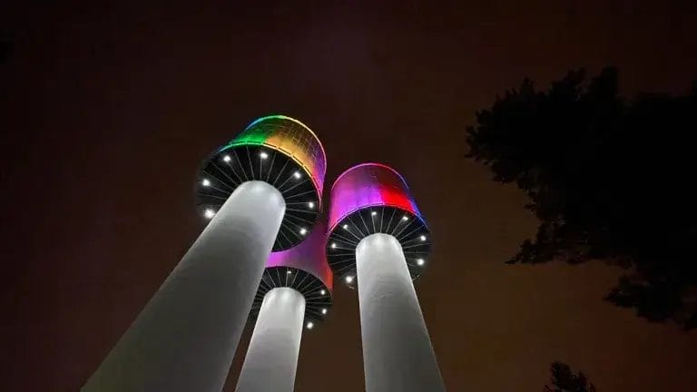 Taskalinmäen kolme vesitornia sateenkaaren värein valaistuna.