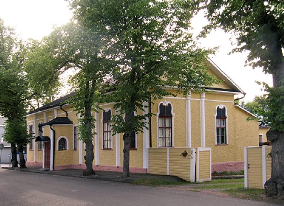 Keltainen talo, jonka edessä puita.