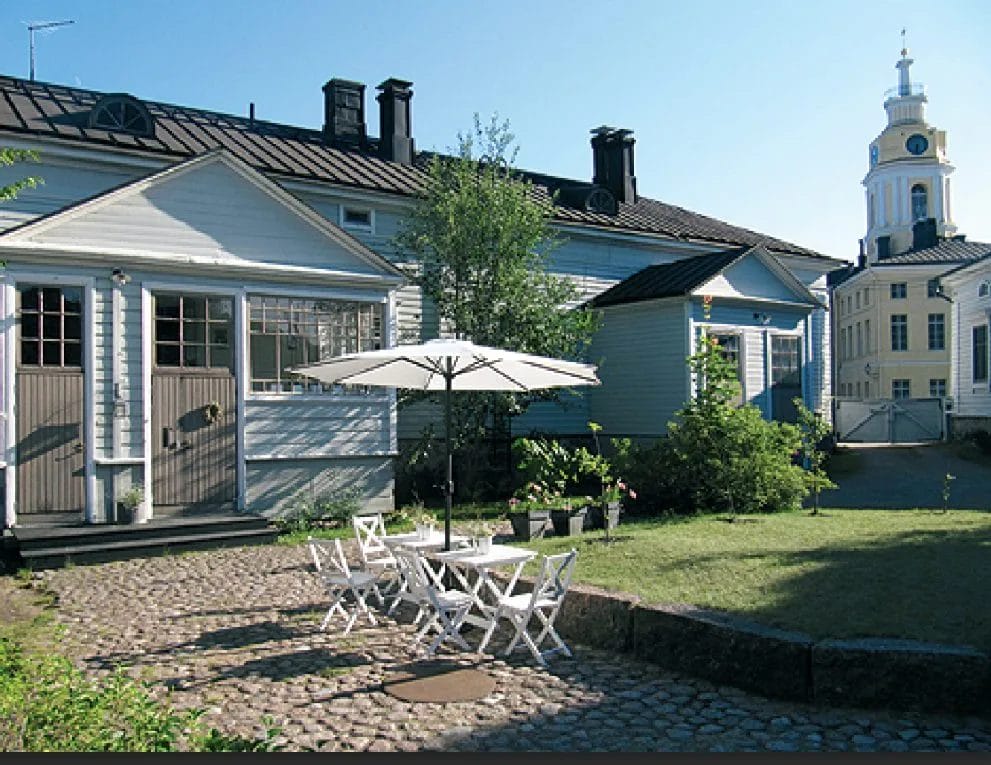 Sininen puutalo, jonka taustalla näkyy Raatihuone.