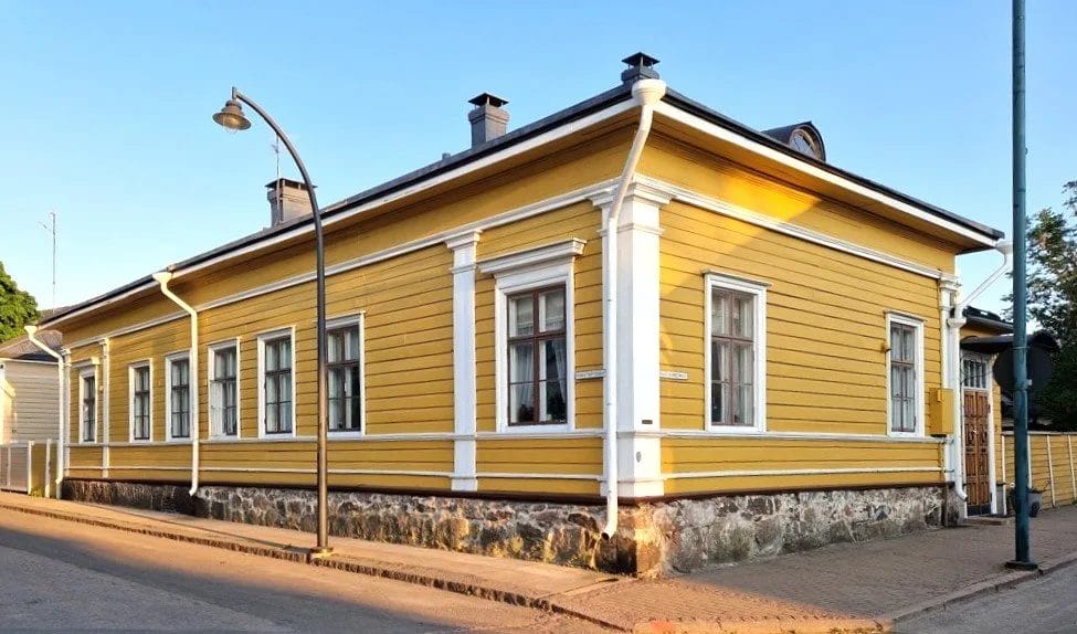 Kirkkaankeltainen puutalo.